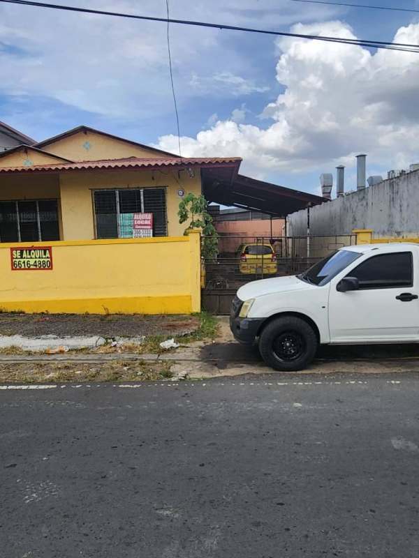 Commercial property in yellow with fenced parking and rental signs in Panama City
