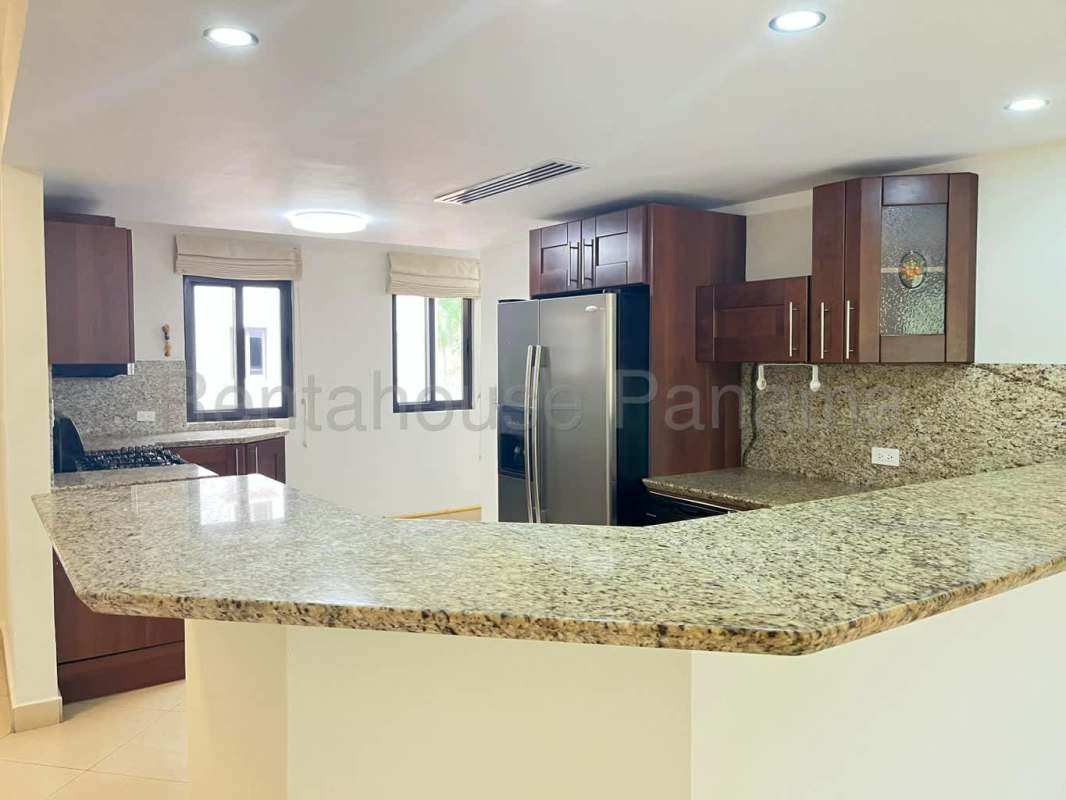 Modern kitchen with granite counters and wood cabinetry in Embassy Club Clayton