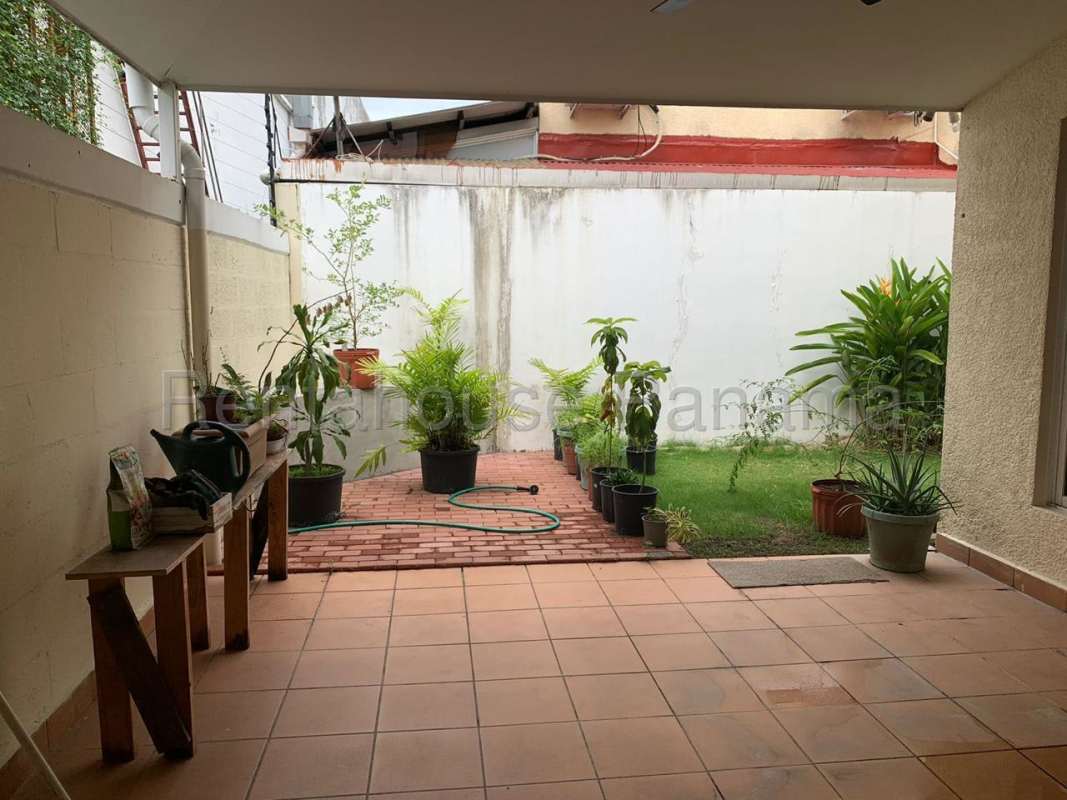 Covered patio and garden area with potted plants and seating in Condado del Rey Panama