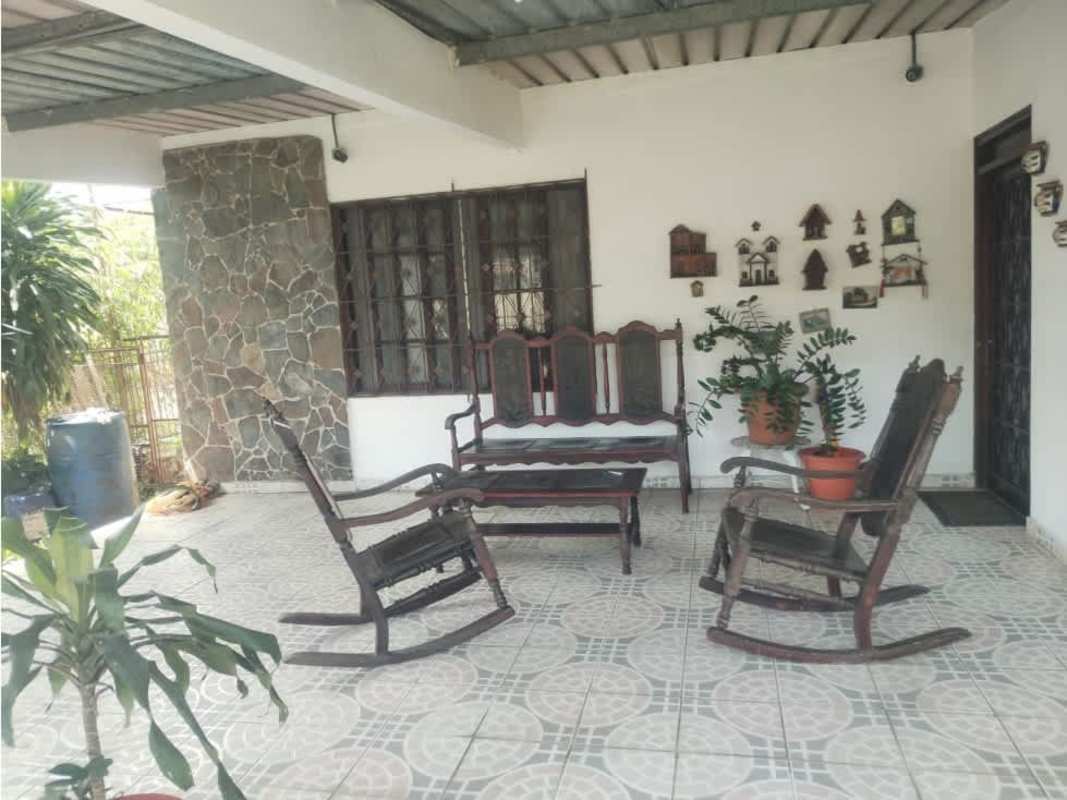 Covered patio with rocking chairs, tiled floor and decorative stone wall in Pacora house