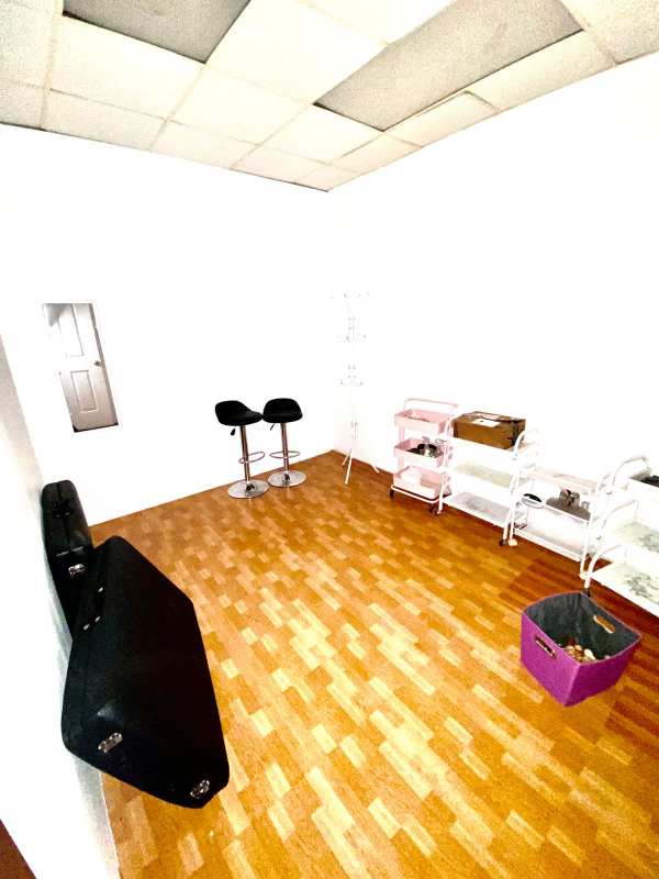 Compact utility storage room with laminate flooring white walls mini fridge in El Dorado Panama