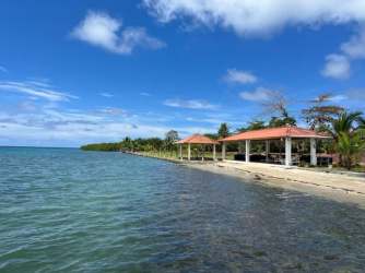 Thatched gazebo with hammock overlooking sunset on the beach in Portobelo Panama