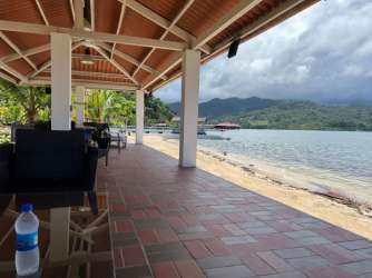 Covered terrace with terracotta flooring overlooking ocean and mountains in Portobelo Panama