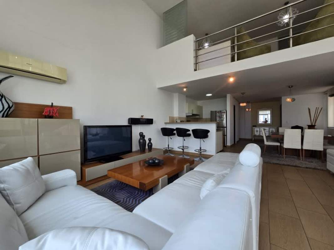 Furnished living dining with double-height ceilings and panoramic windows in PH El Cangrejo Loft