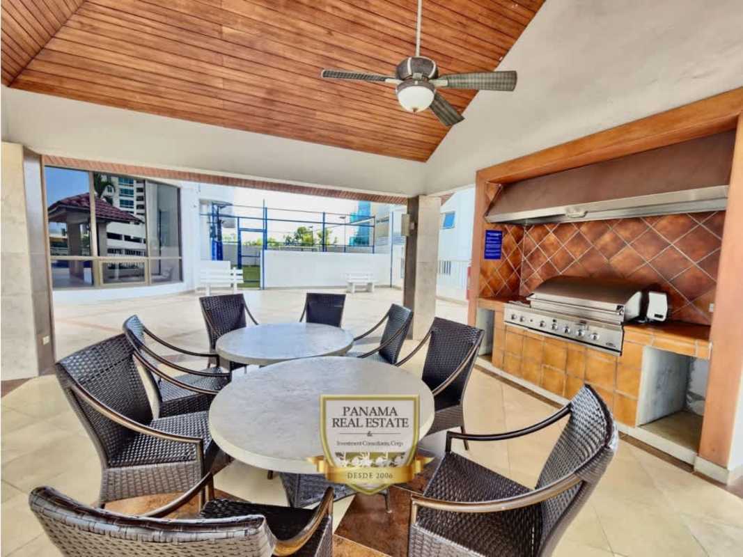 Large modern kitchen with granite countertops, bar island, wood cabinetry, Costa del Este skyline in PH Panama Bay Panama