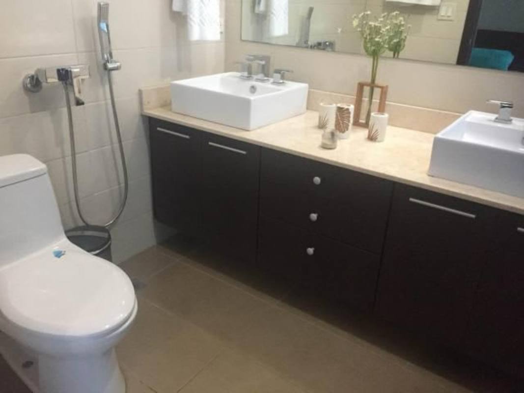 Master bedroom with en-suite bathroom, large windows, modern furnishings in PH Country Club Costa del Este apartment Panama City