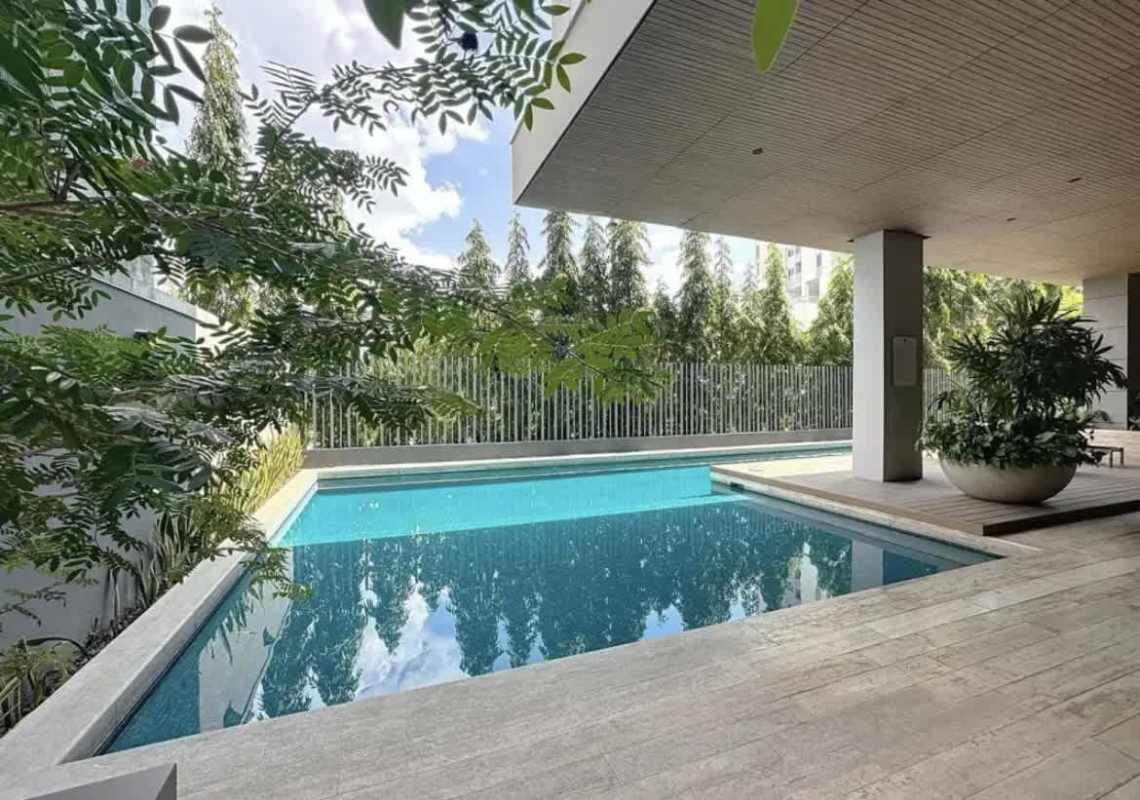 Swimming pool with sun deck lush landscaping and covered lounge area PH Azalea Santa María Panama