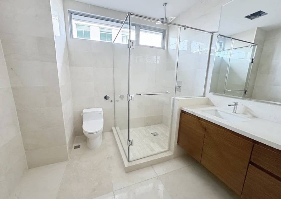Modern bathroom with wood vanity large mirror and adjacent walk-in closet PH Azalea Santa María Panama