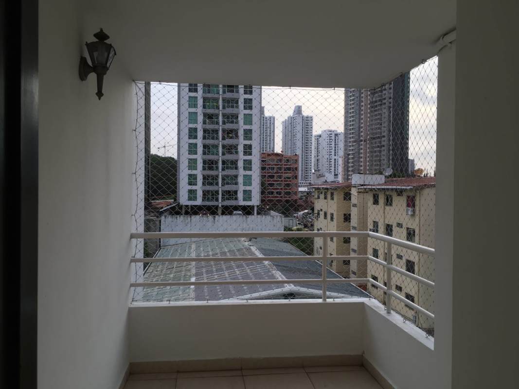 Bathroom with pedestal sink, mirror cabinet, toilet, tiled walls in PH HIP Tower apartment Panama
