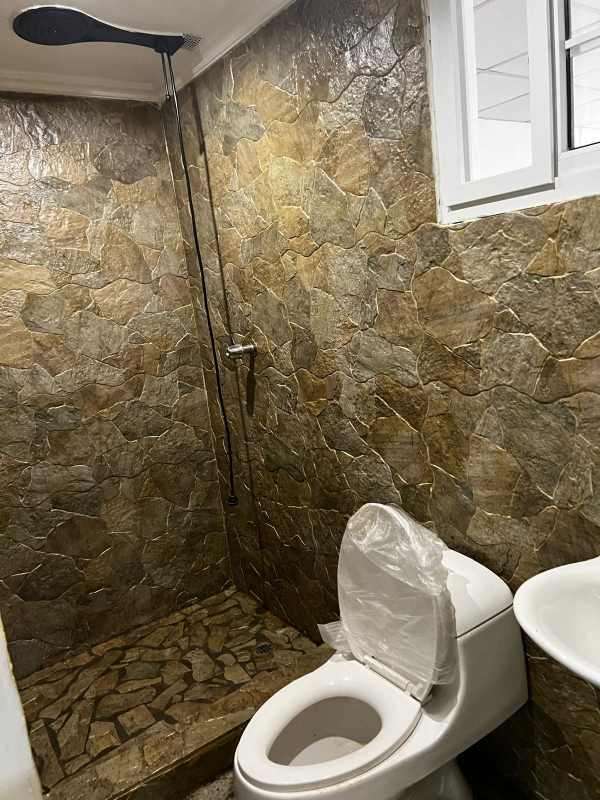 Rustic bathroom with stone tiles, rain shower, Betania rental house in Panama