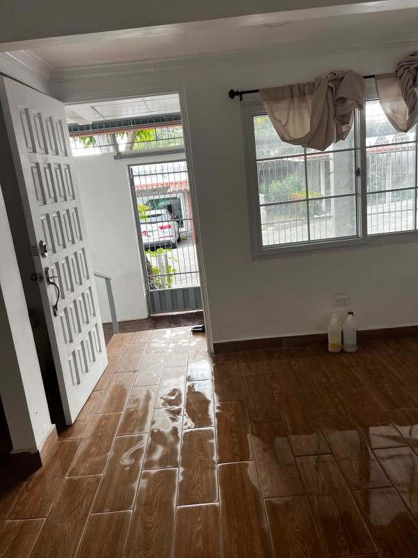 Entryway or living room with brown tile floor, large window, at Betania rental house in Panama