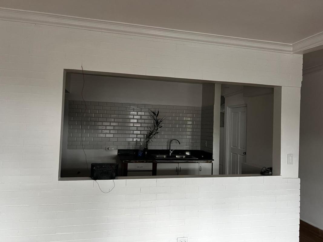 Modern kitchen with white subway tiles, black countertop, in Betania rental house Panama
