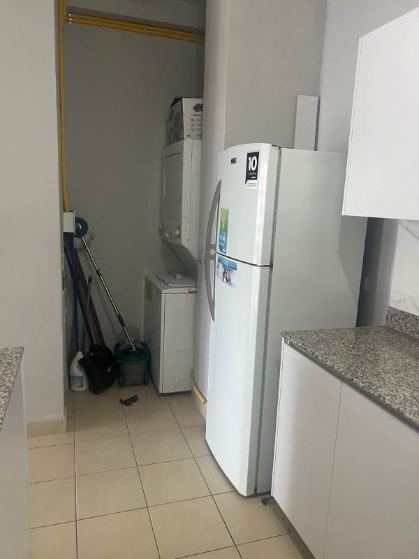 Kitchen area with refrigerator and stacked washer dryer in PH Las Hortensias Panama City