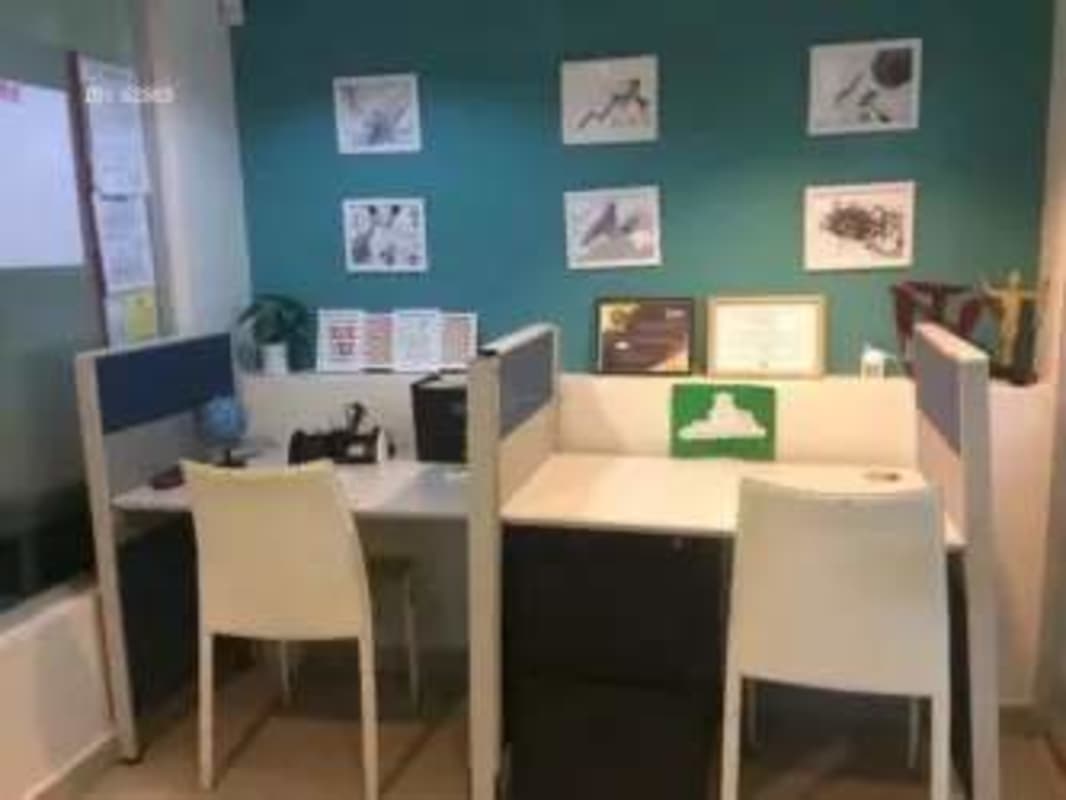 Small private office workspace with teal wall, glass partition, and workstations in PH Plaza Hato Pintado