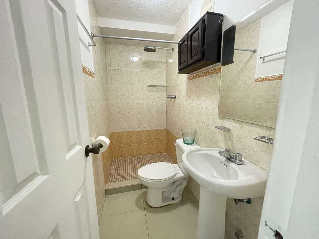 Small bathroom pedestal sink toilet walk-in shower tiled walls Betania Panama