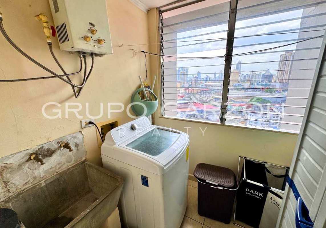 Laundry room with concrete sink, water heater, ventilation window and city view at PH Sunset Place Panama City