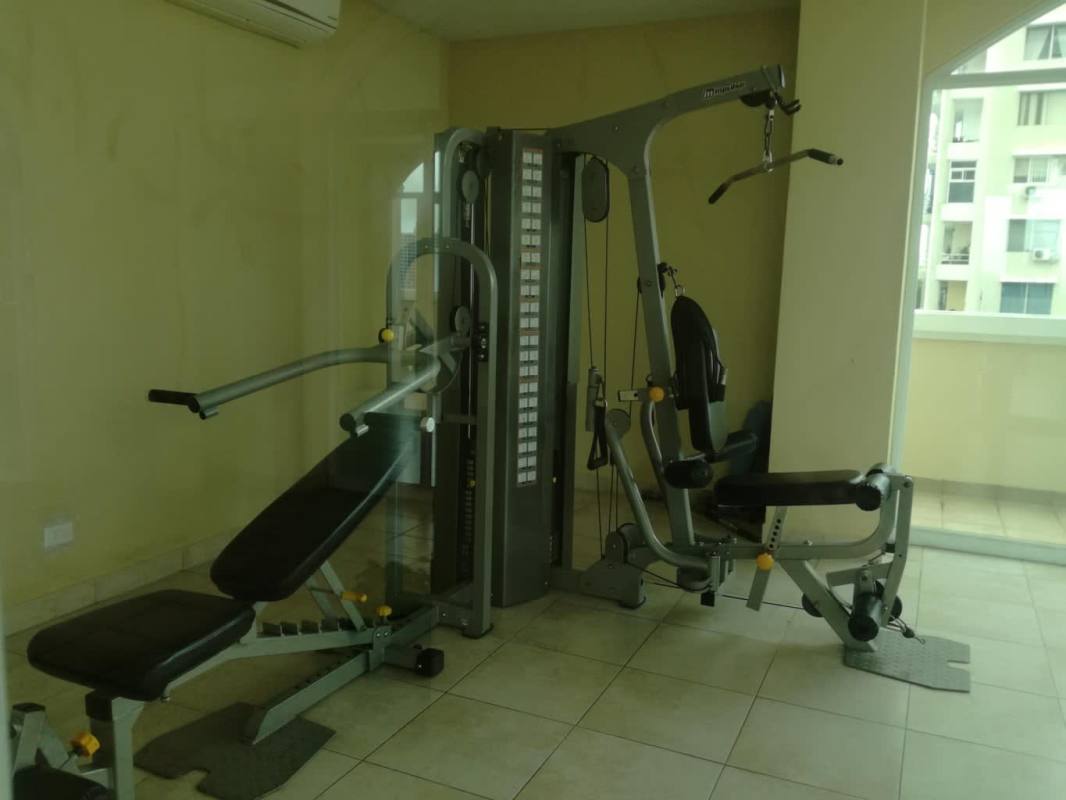Indoor gym with modern fitness equipment, multi-station machines at Porto Fino San Francisco Panama
