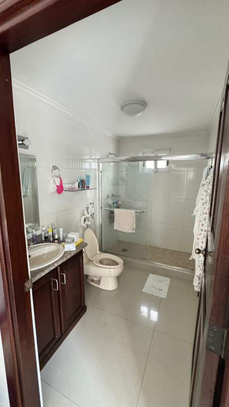 Contemporary bathroom with glass shower and granite vanity in Altos del Golf house Panama