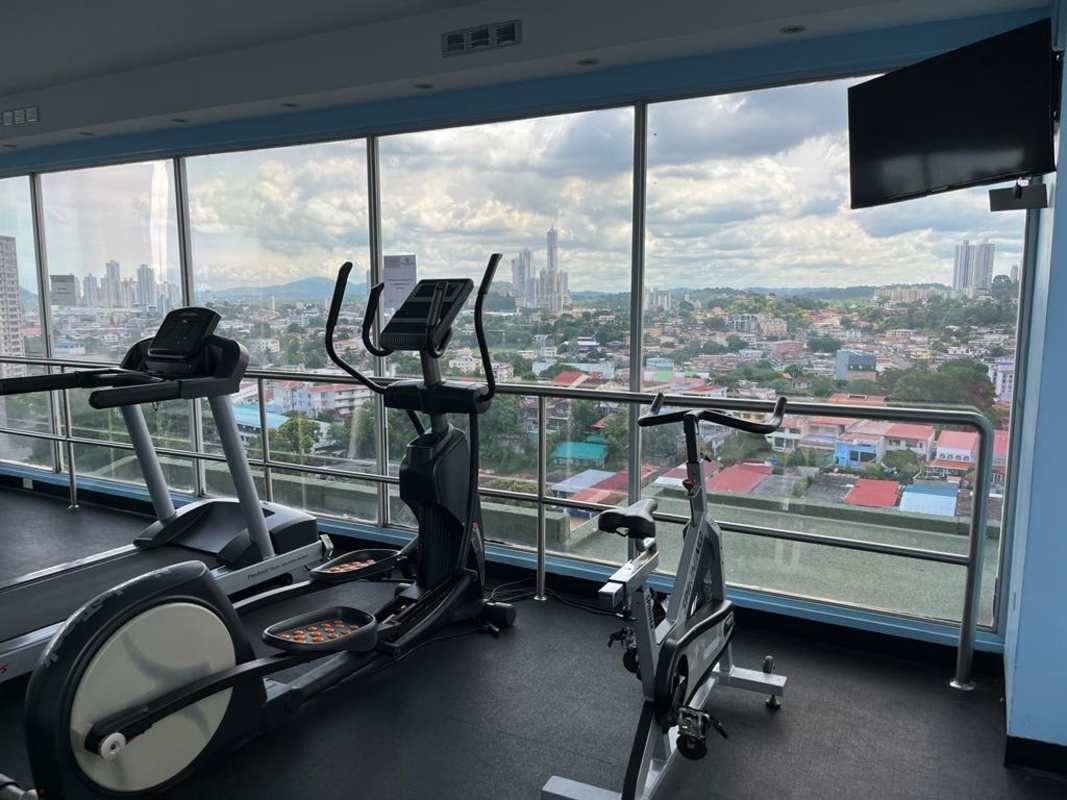 Condominium gym with cardio equipment, panoramic windows, panoramic skyline view in Panama City