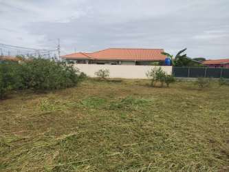 Cleared lot with bushes, wall, fence, and neighbor house in Monagrillo Chitré Panama
