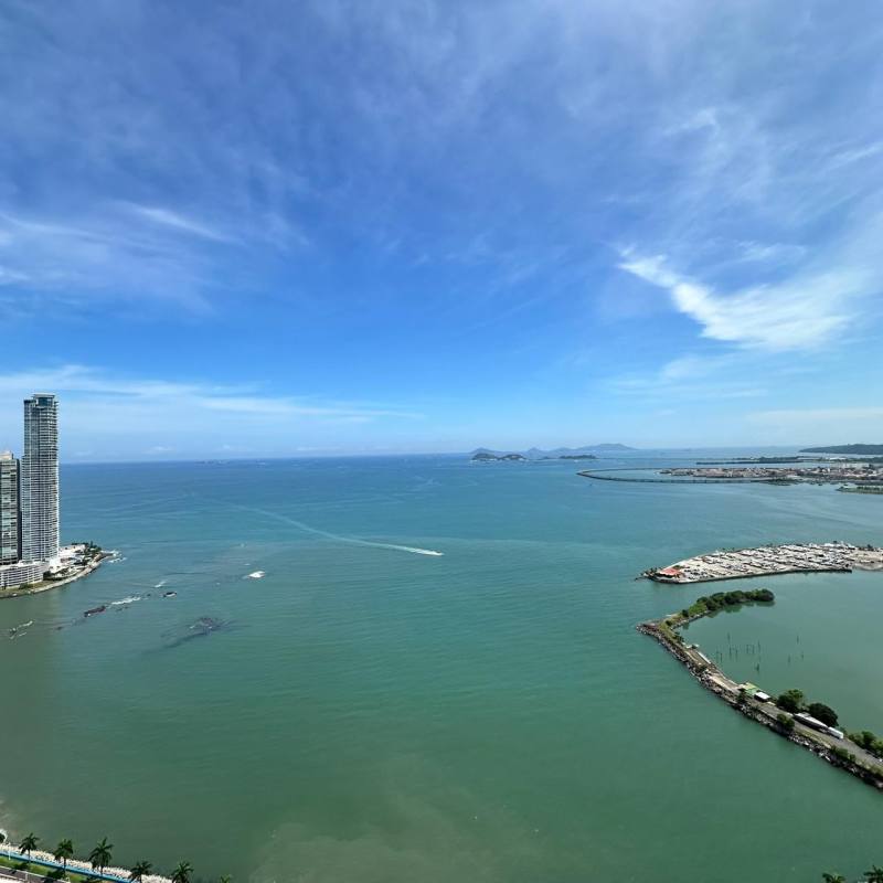 Modern bedroom with upholstered bed, large windows, neutral decor and panoramic city views in PH Yoo Panama