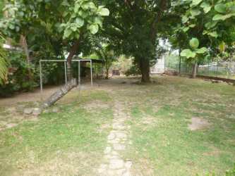 Large fenced backyard with shade trees swing set in Coronado beach house Panama