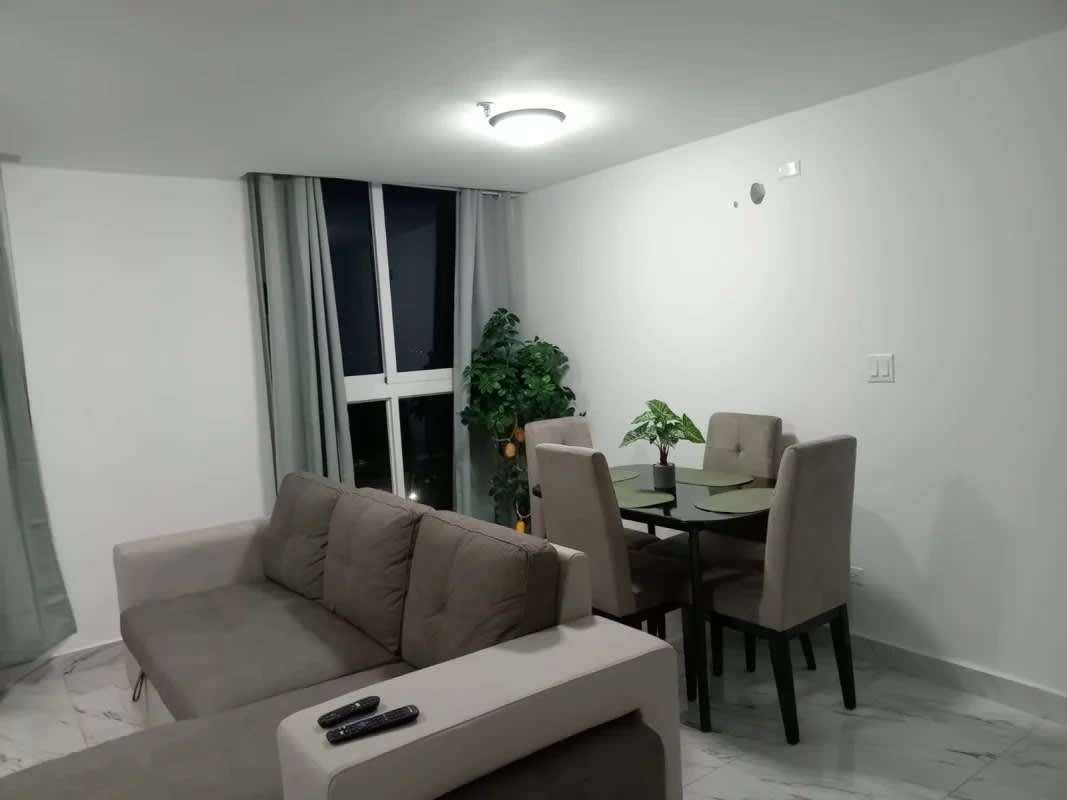 Furnished living and dining space with large windows ocean-city views in PH BICSA Panama City