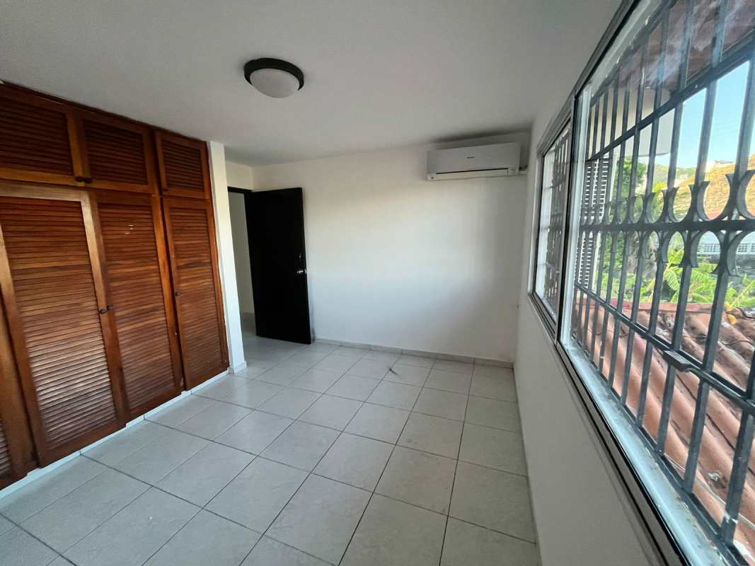 Bedroom with closet, tiled floor, and large window in Limajo duplex house for sale