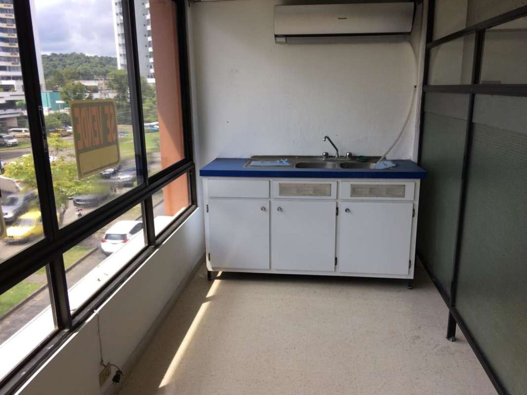 Compact kitchenette in commercial office with double sink and large windows Panama City