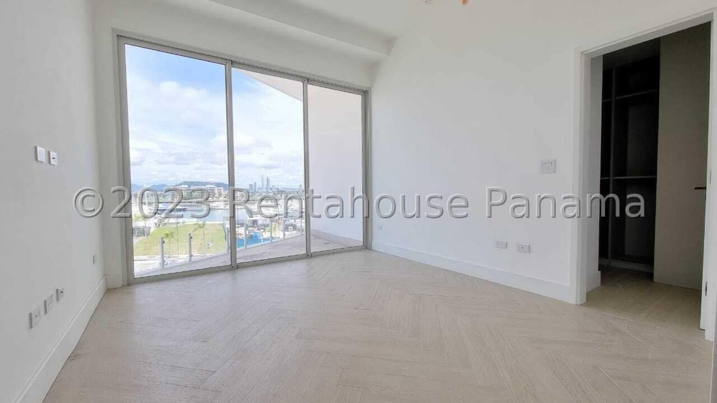 Bright bedroom with floor-to-ceiling glass doors walk-in closet in Panama Ocean Reef apartment