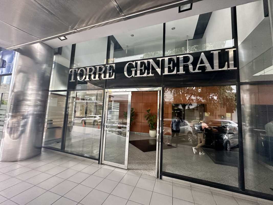 Modern glass entrance of Torre Generali skyscraper in Panama City's financial district