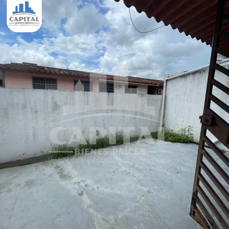 Concrete patio yard enclosed by white wall and iron gate Betania Panama City house