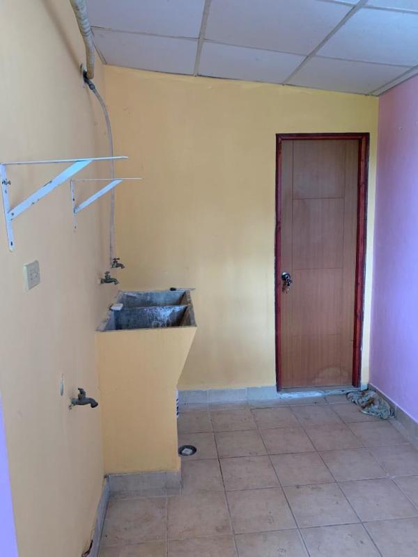 Enclosed laundry room with utility sink, tile walls and purple accents in Ciudad San Lorenzo La Cabima