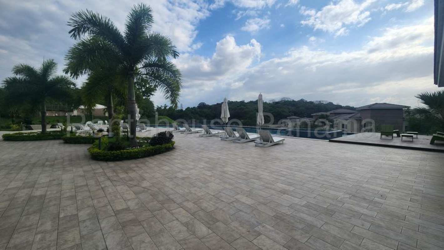 Wooden deck, poolside chairs and umbrellas surrounded by tropical gardens Altos de Panamá