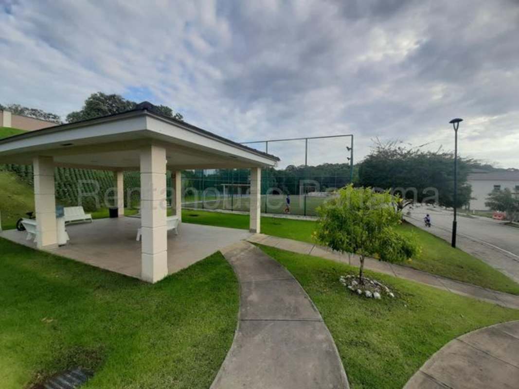 Outdoor communal gazebo area with benches, tennis and multi-sport courts Condado del Rey