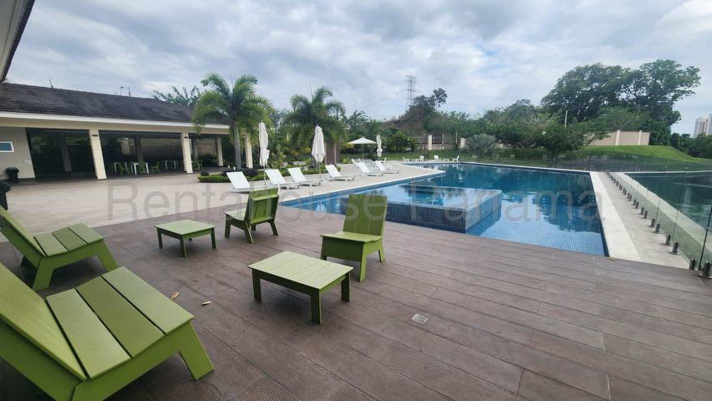 Luxury community swimming pool with lounge chairs, umbrellas, palm trees Altos del Parque