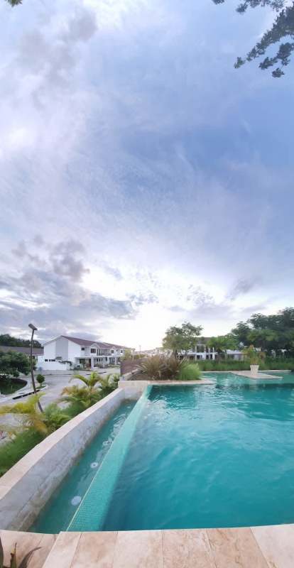 Large swimming pool surrounded by gardens at Sierra Nevada Residences Brisas del Golf Panama City