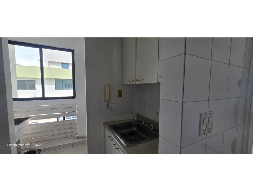 Minimalist kitchen with white cabinets, window with grid, tiled walls in PH Royal Center Panama
