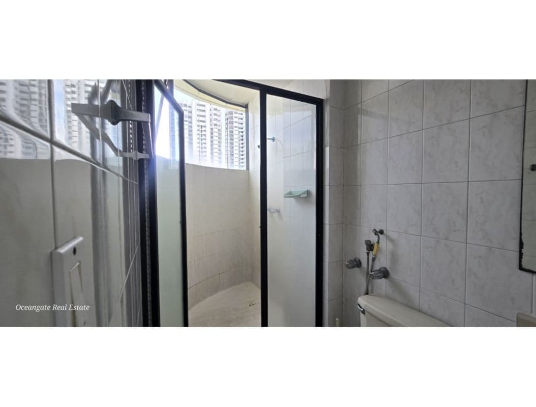 Modern bathroom with glass shower, white ceramic tiles, window for ventilation in PH Royal Center Panama