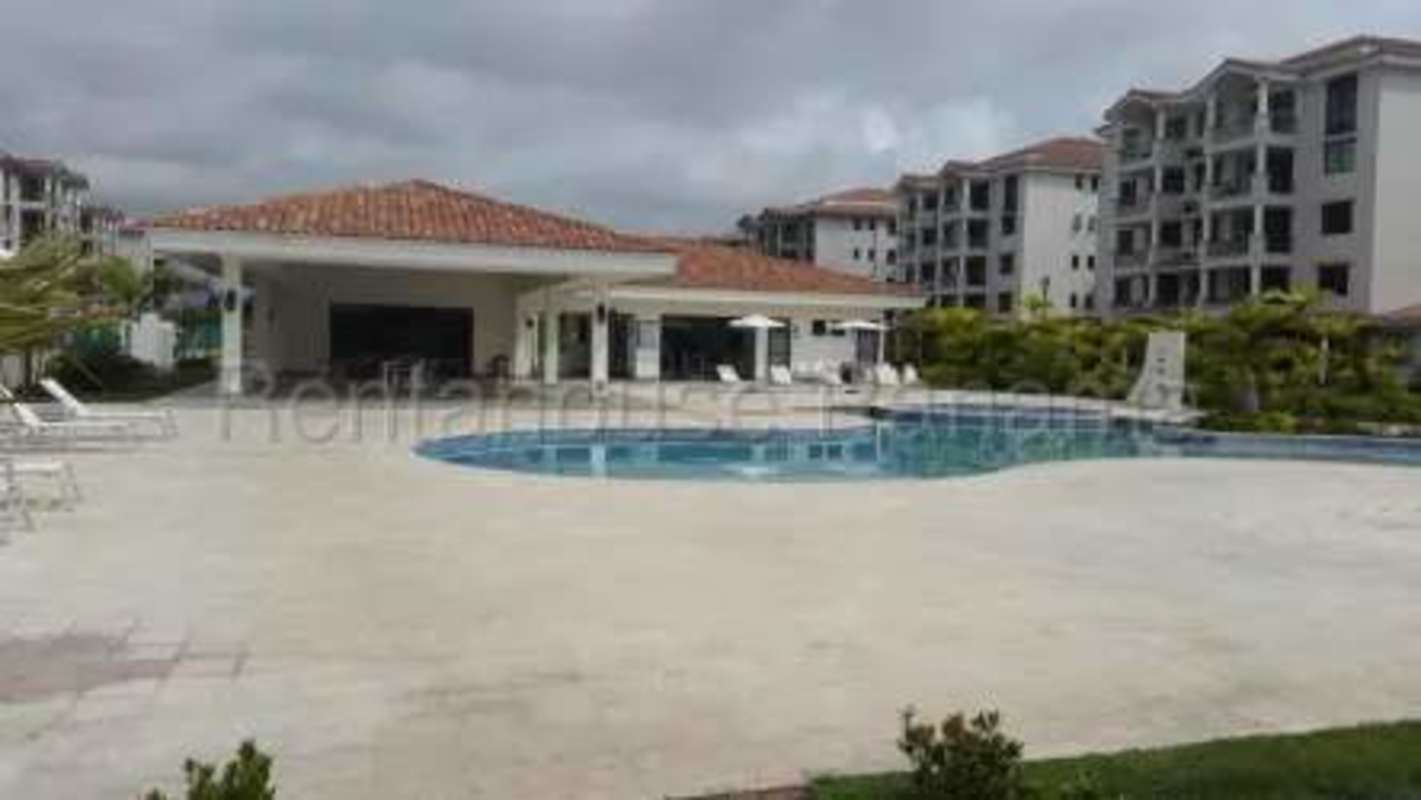 Swimming pool with lounge chairs in gated community Costa Sur Panama apartment amenities