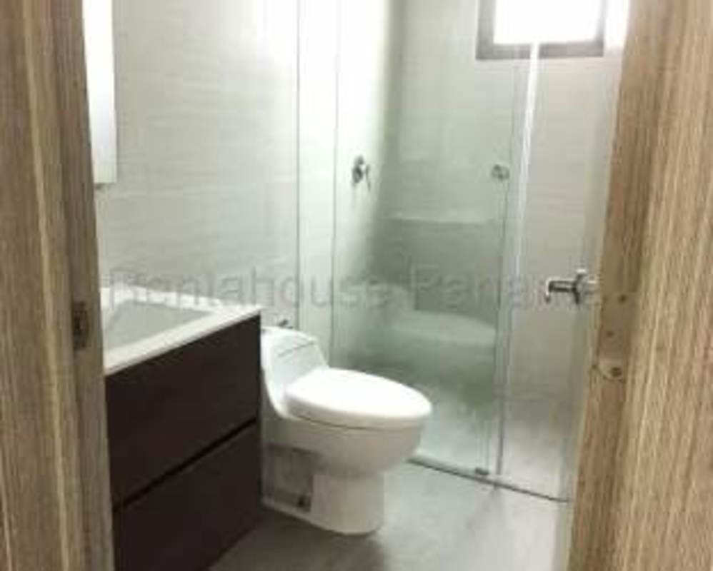 Modern bathroom with glass shower, tile floor and vanity in Panama Costa Sur apartment 