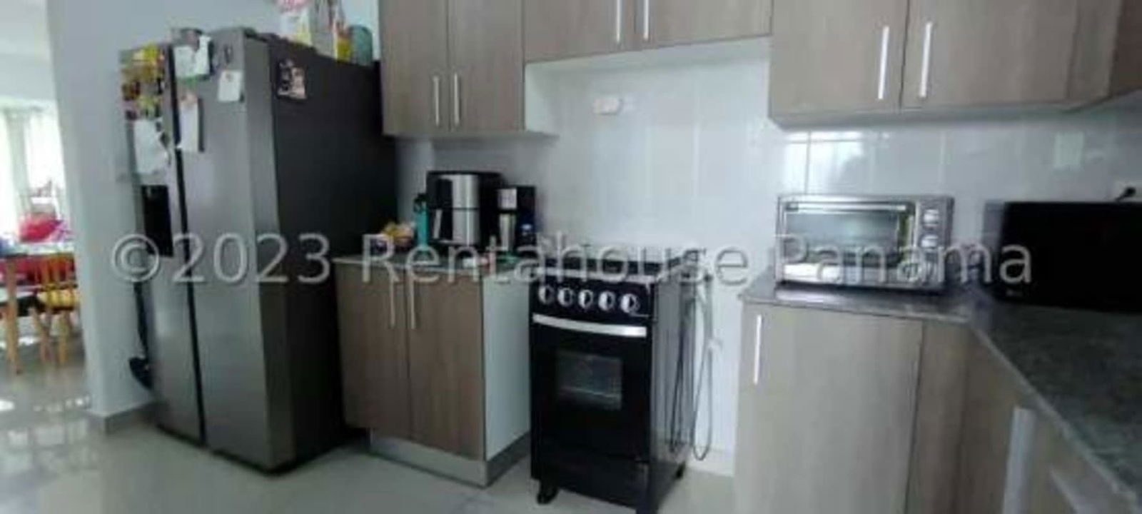 Modern kitchen with refrigerator, oven, granite counters in PH Sunshine By The Park Carrasquilla Panama City