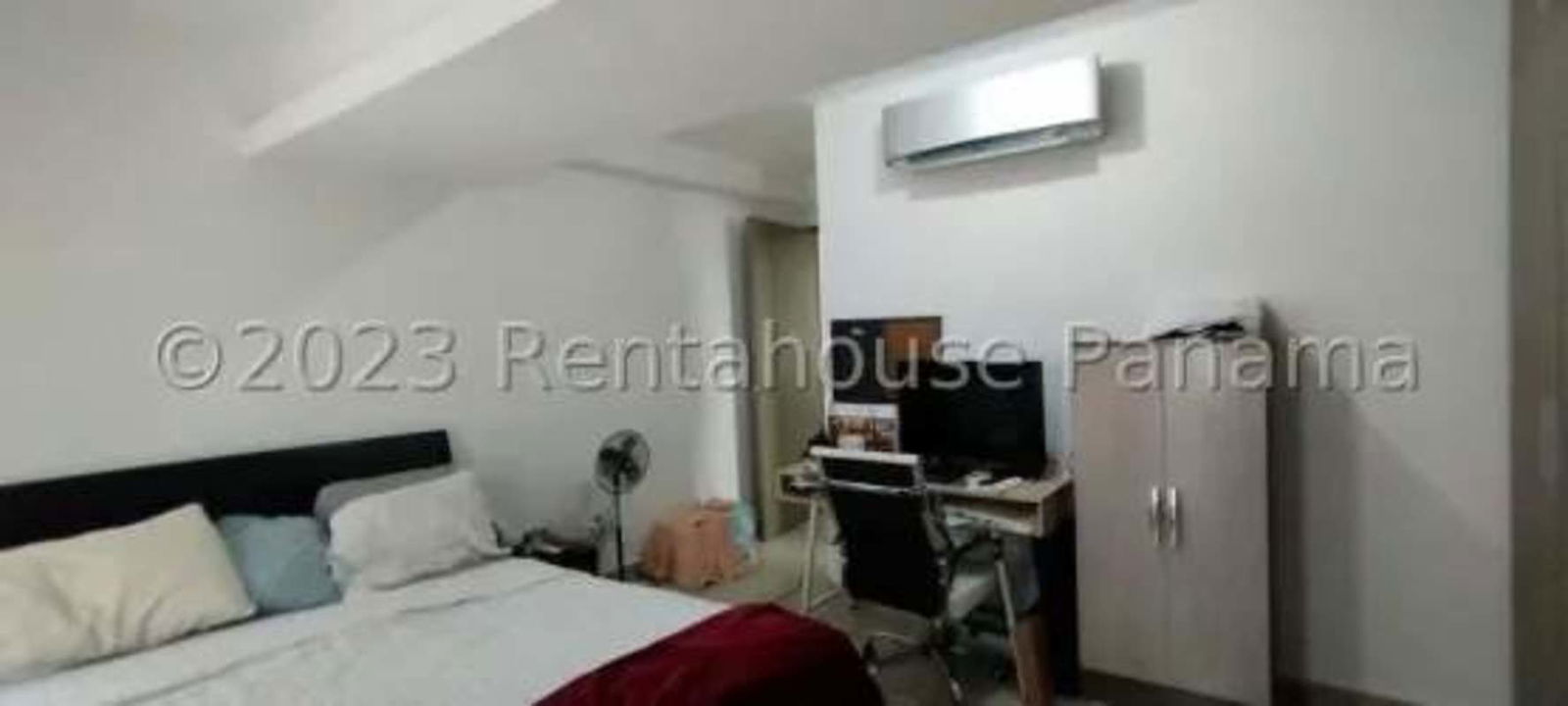 Bedroom with work desk, bed, AC unit and window views in Carrasquilla Panama apartment