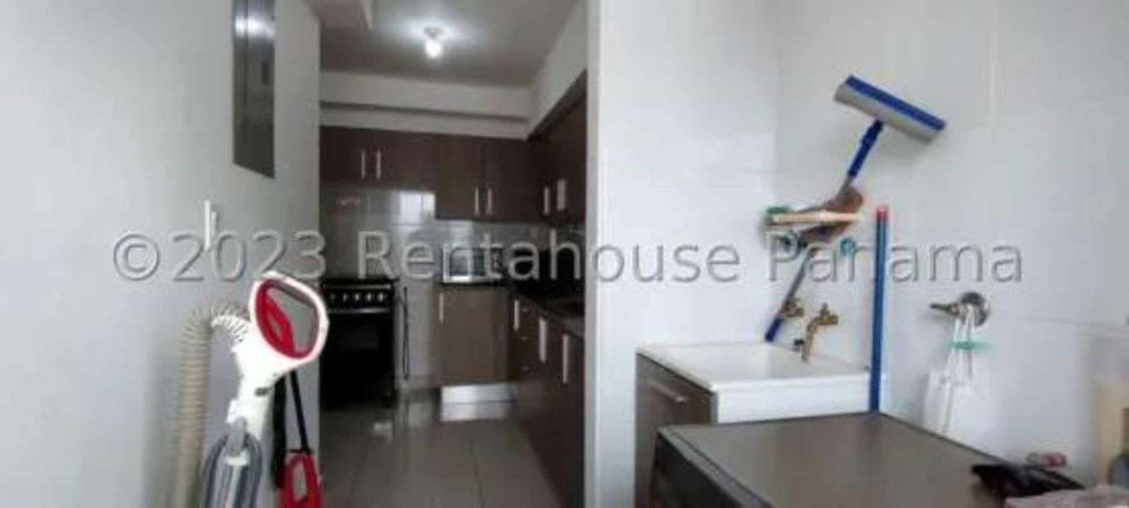 Modern kitchen with granite countertops, appliances, adjoining laundry with washer, Carrasquilla Panama apartment