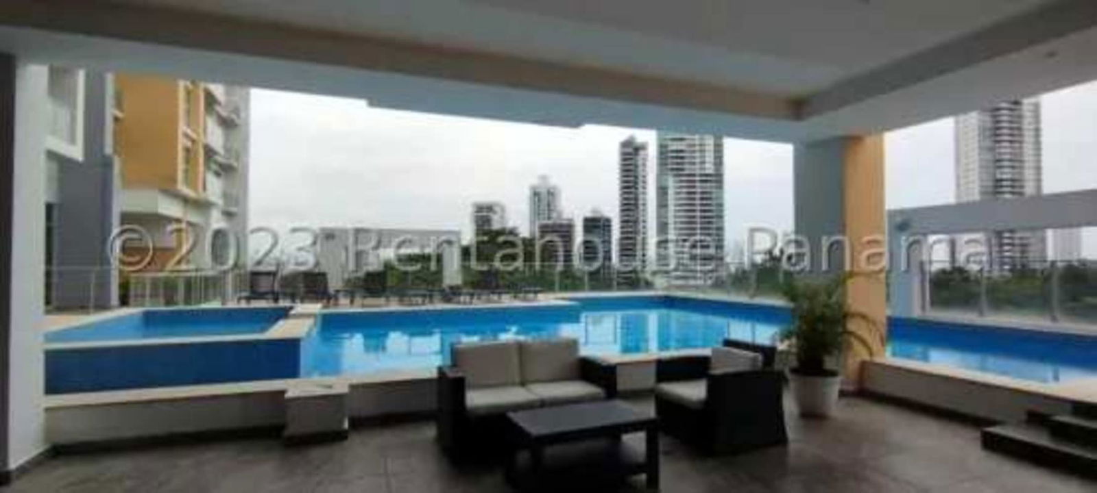 Outdoor swimming pool with seating area covered terrace city views Panama City Carrasquilla