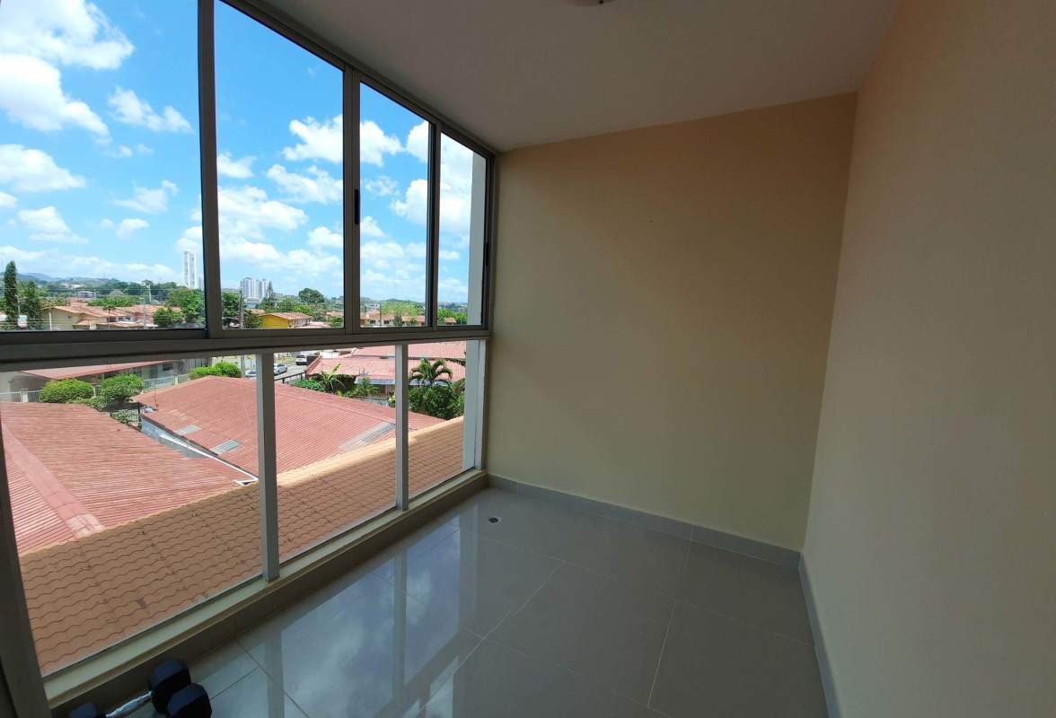 Enclosed sunroom or balcony space with panoramic windows overlooking Chanis neighborhood inside PH Creta La Fontana Panama