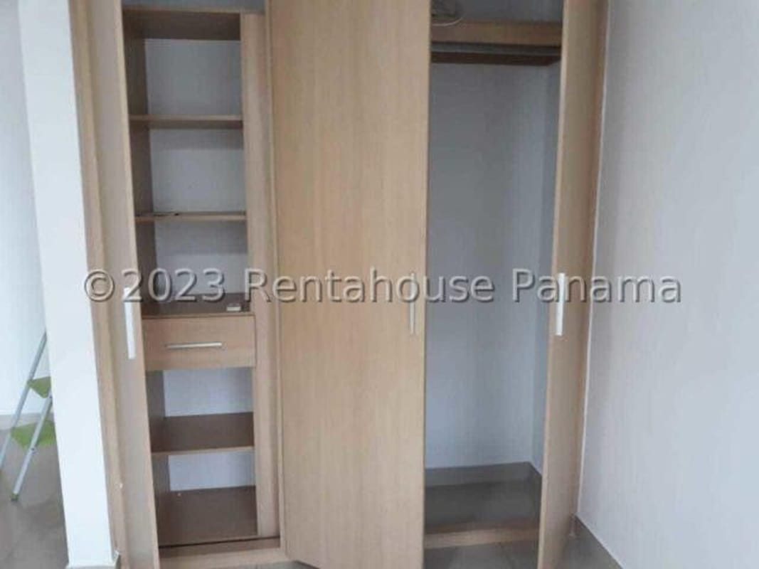 Walk-in closet space with multiple built-in wooden shelves and drawers in PH Citrus Panama