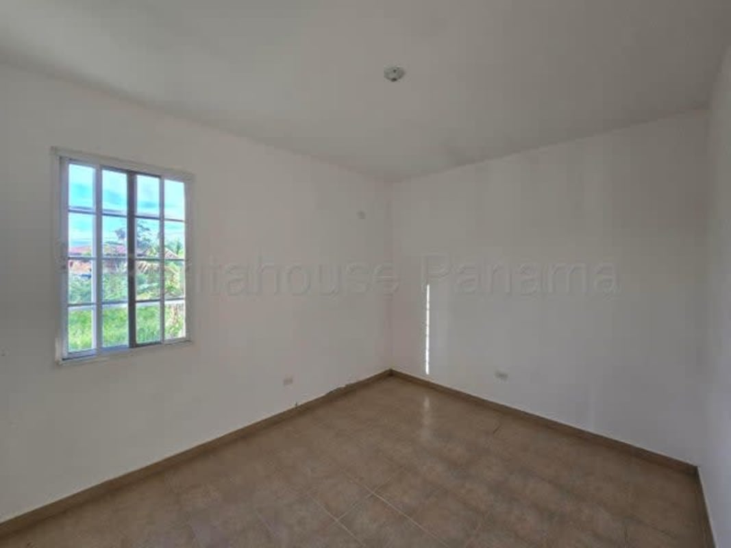 Minimalist bedroom with window view natural light ceramic tiles in Pacora house Panama
