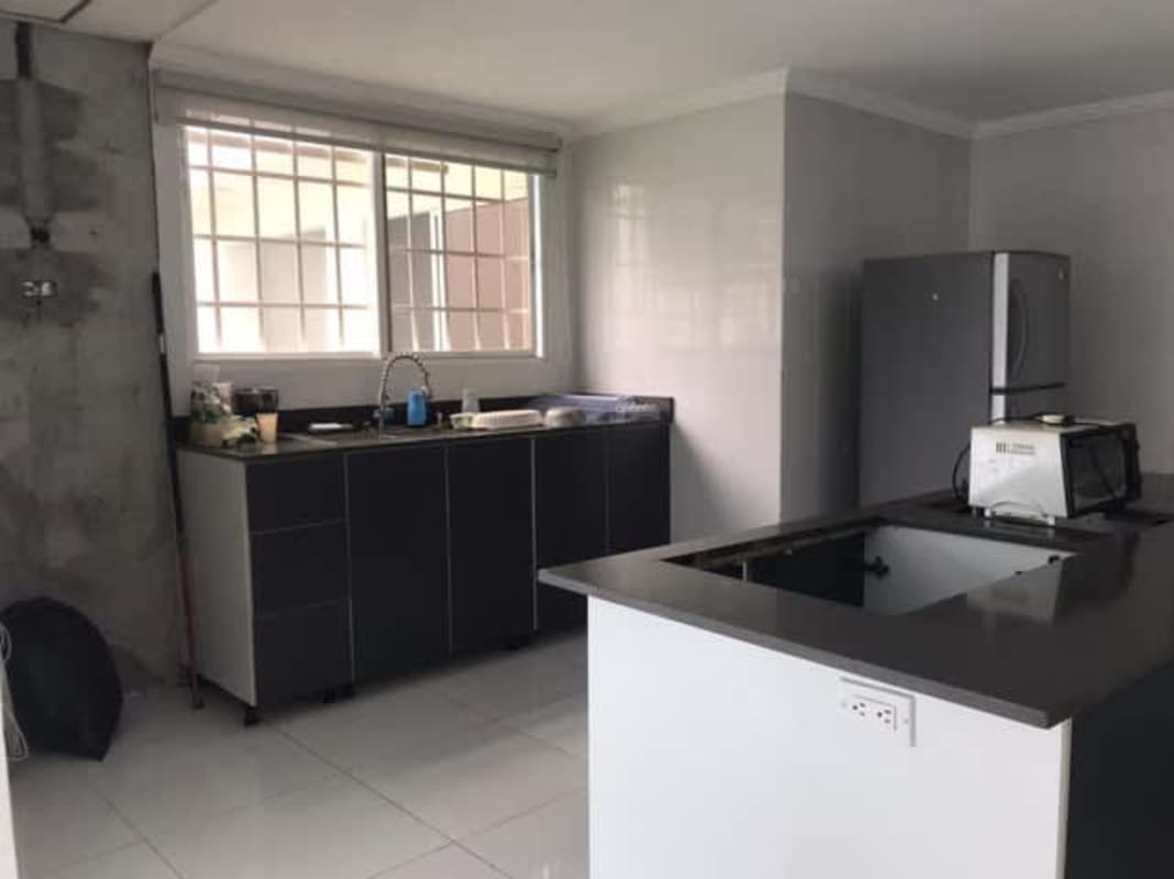 Modern kitchen with central island, large windows, ceramic tiles at Brisas del Golf Panama