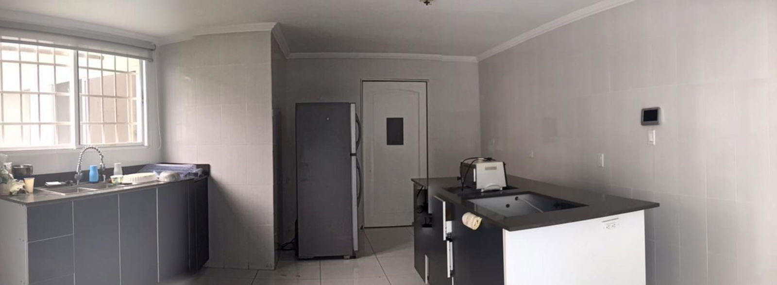 Modern living room with white cabinetry blue LED lighting ceiling fans in house Brisas del Golf Panama